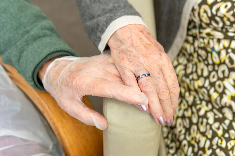 care home resident holding hands